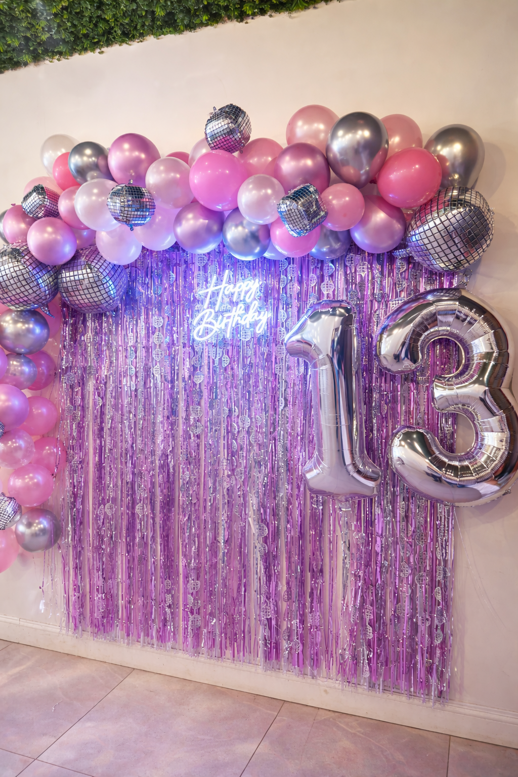 Pink, silver and lavender balloon arch with disco balls and a giant 13 balloon