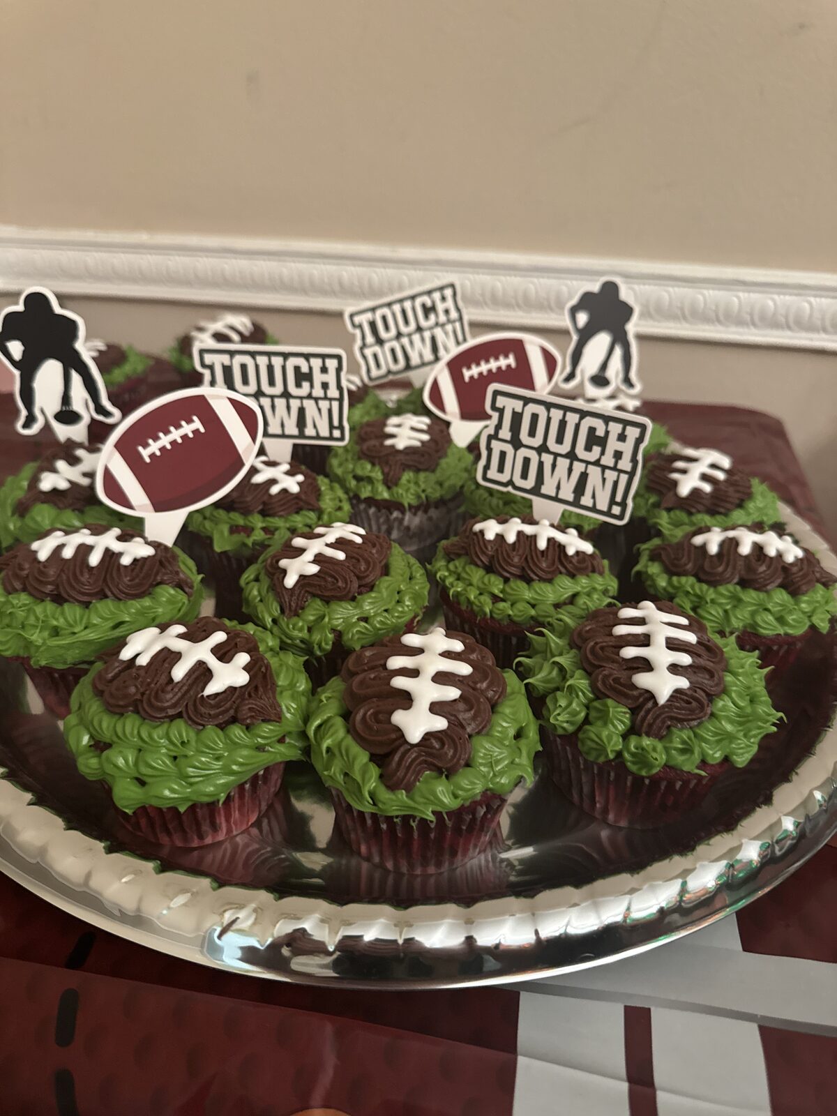 Football cupcakes with chocolate laces and green grass icing topped with Touchdown picks