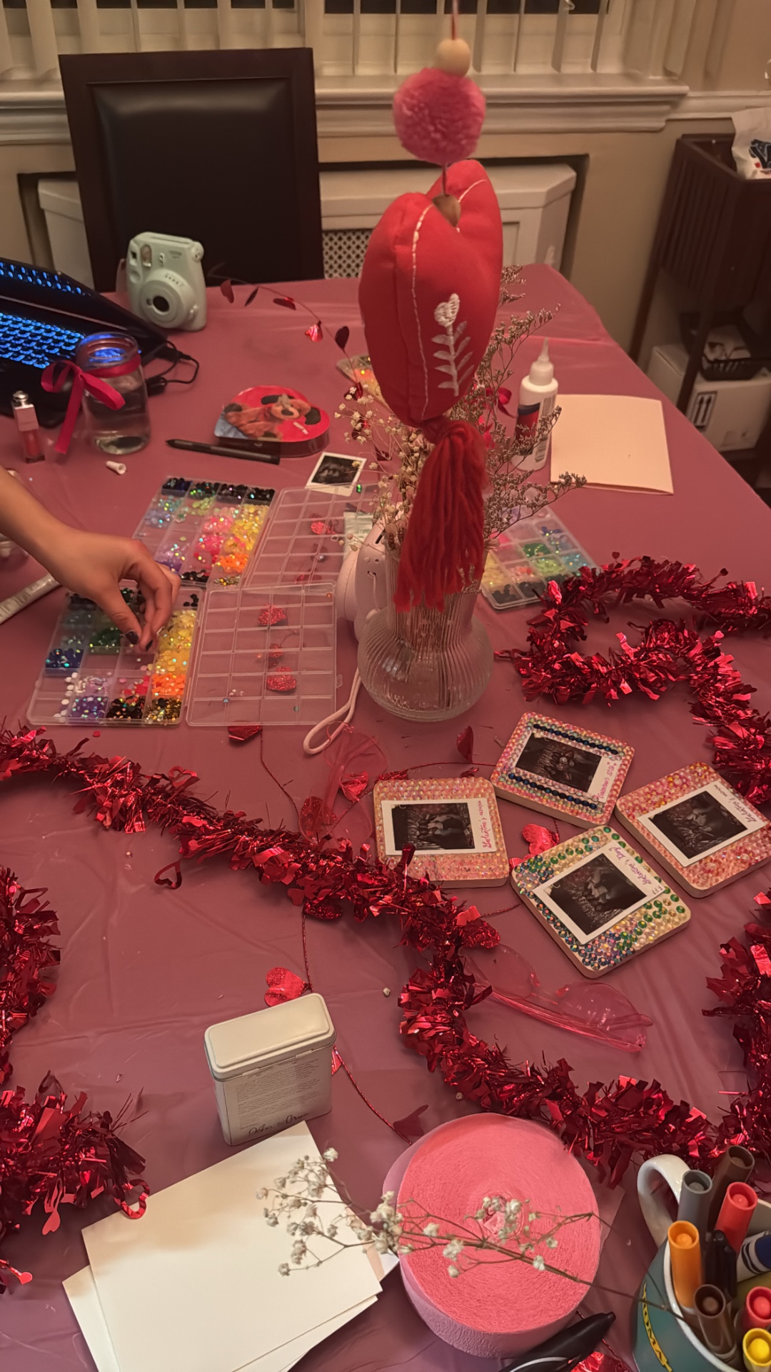 Bead and rhinestone craft station with bedazzled instant photo frames in pink and red