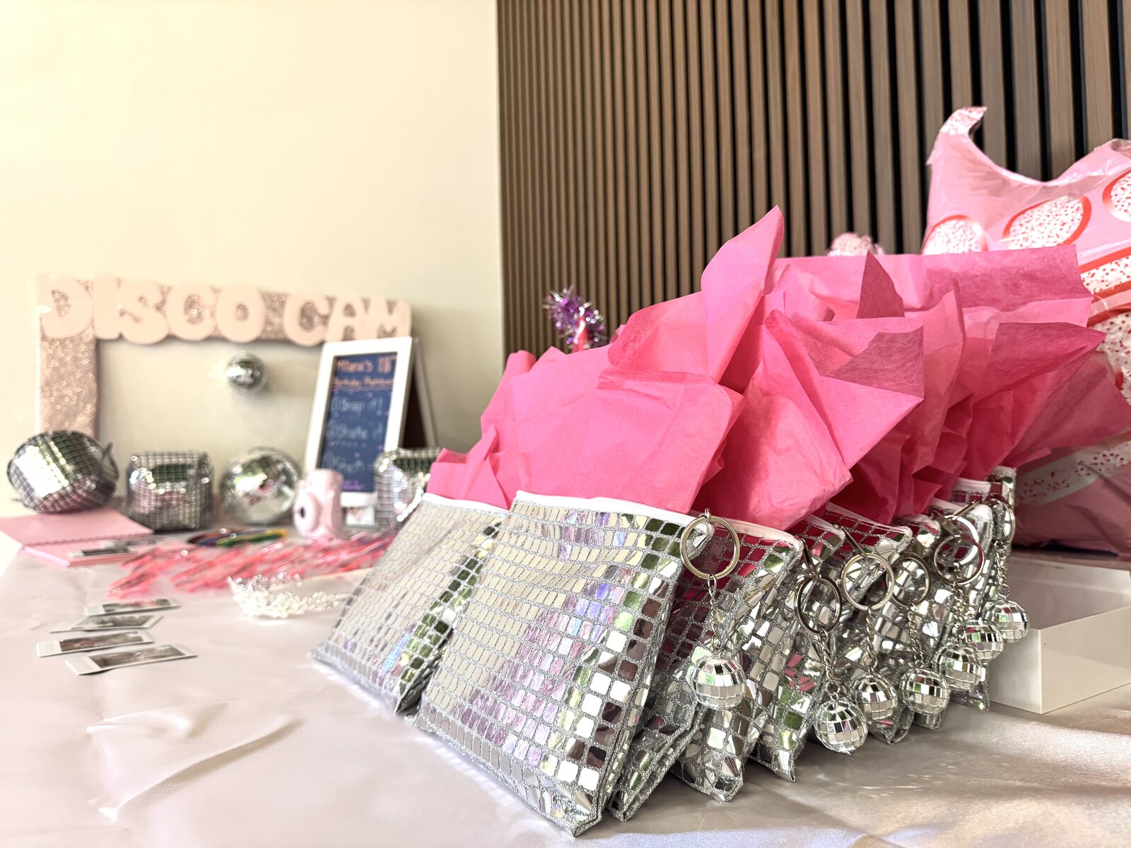Disco favor table with pink tissue tote bags and mirror clutches